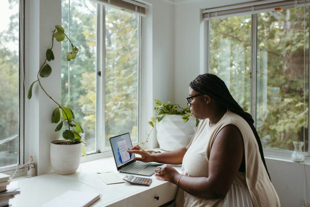 a woman sitting at a table with a laptop - How to start a home based business online